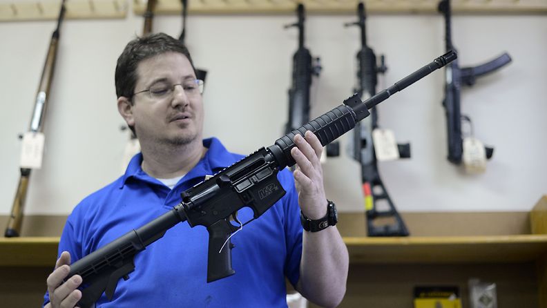Asekauppias esittelee samantapaista rynnäkkökivääriä, jota käytettiin muun muassa Sandy Hookin kouluampumisessa.