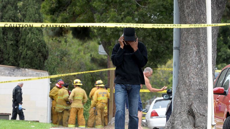 Asukas puhuu puhelimeen asuinalueella Los Angelesissa Kaliforniassa. Asuinalueella ammuttiin useita ihmisiä. 