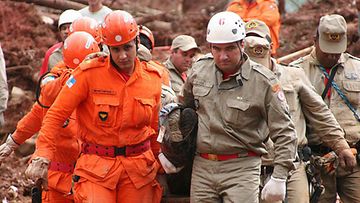 Pelastustyöntekijät kantavat maanvyöryn uhria Brasiliassa.