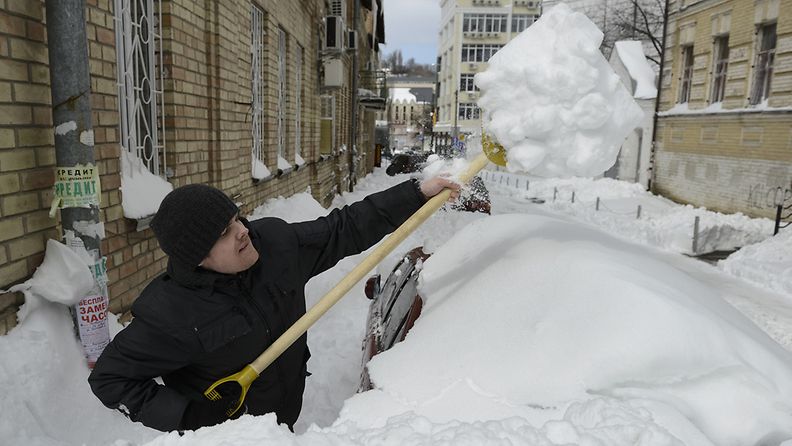 Mies lapio lunta Kiovassa Ukrainassa 25. maaliskuuta 2013.