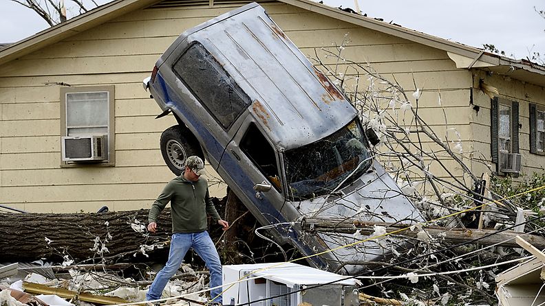 Mies tutkii tornadon tuhoja kotipihallaan Oklahoman Tushassa Yhdysvalloissa 15.4.2012.