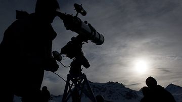 Mies tutkailee auringonpimennystä Francois-Xavier Bagnoudin observatoriossa Sveitsissä 4.11.2011. Kuva: EPA