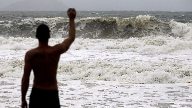 Turisti kuvasi suuria aaltoja rannalla Hong Kongia uhkaavan myrskyn alla 23. heinäkuuta 2012. EPA