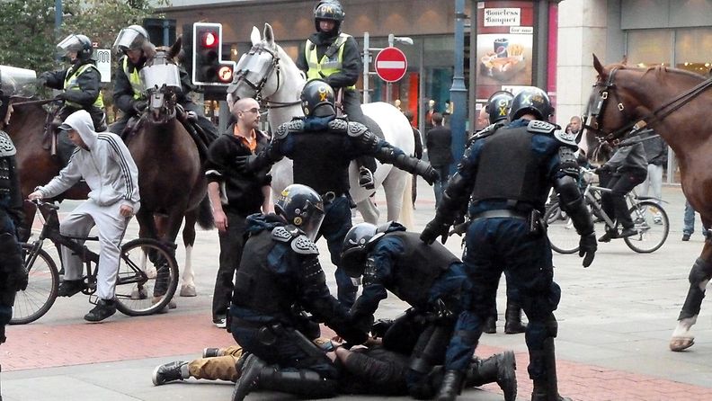 Poliisit taltuttavat mellakoitsijaa Manchesterin keskustassa 9.8.2011. EPA