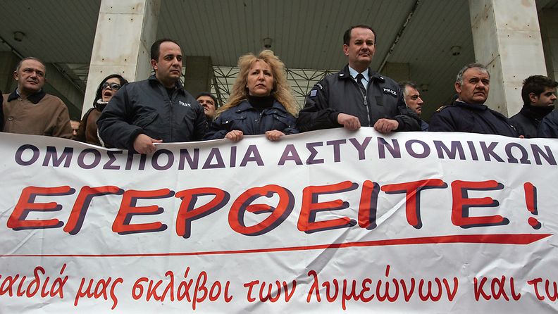 Poliisit pitelivät "Nouskaa vastarintaan"-tekstillä varustettua banderollia pääpoliisilaitoksen edessä Ateenassa 9. helmikuuta. 