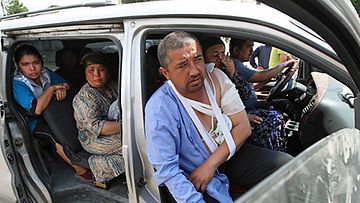 Perhe lähdössä pakoon Uzbekistanin rajalle Oshin kaupungissa 15.6.2010. Kuva: Epa