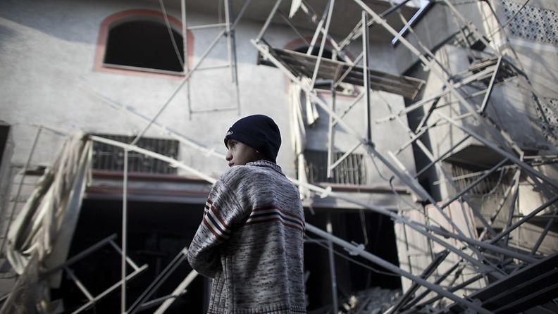 Palestiinalaispoika katselee rakennusta, joka tuhoutui Israelin ilmaiskussa 19. marraskuuta 