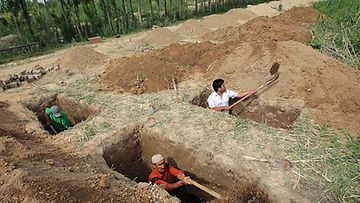 Miehet kaivavat hautoja Oshin kaupungissa levottomuuksissa kuolleita uhreja varten. Kuva: Epa