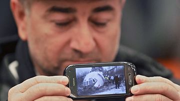  Magomed Magomedov näyttää onnettomuuskoneesta ottamaansa kuvaa kännykällään. (EPA)