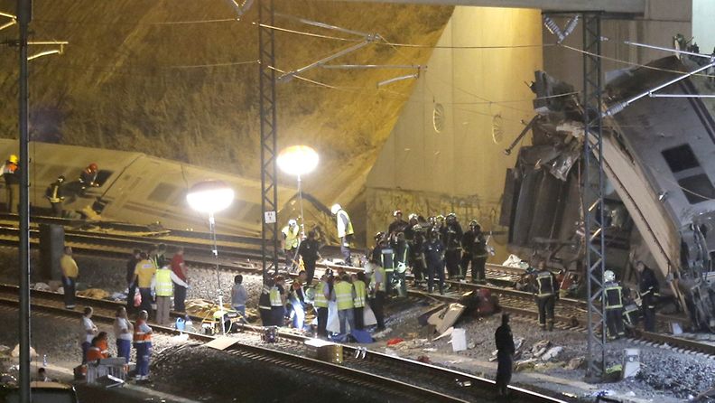 Pelastushenkilökunta työskentelee uhrien pelastamiseksi turmajunan luona Pohjois-Espanjassa.