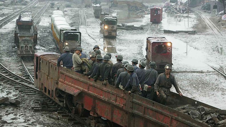 Rescuers come out of a pit in Longtan Colliery, where a flood killed 12 miners and left 16 missing, on October 6, 2005 in Guangan of Sichuan Province, southwest China. 