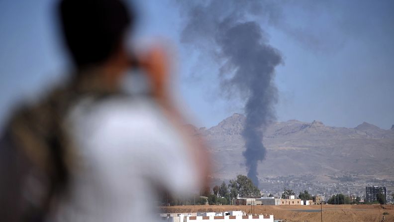 Jemeniläinen mielenosoittaja kuvaa savupatsasta Jemenin pääkaupungissa sanaassa tammikuussa 2012.