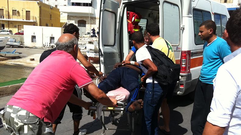 Poliisien ja maahanmuuttajien yhteenotossa loukkaantunutta henkilöä siirretään ambulanssiin Lampedusassa Italiassa 21. syyskuuta 2011. (EPA)