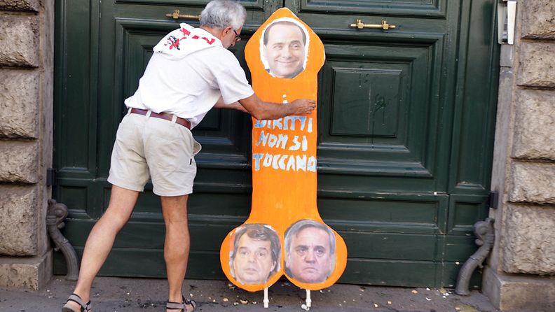A cardboard cutout of a male organ with pictures of Italian Prime Minister Silvio Berlusconi (top); Maurizio Sacconi (R-bottom), Minister of Labour and Social Affairs and Renato Brunetta, Minister of Public Administration and Innovation leans on the door of the Ministry of Public Administration during a general strike, Rome, Italy, 06 September 2011.