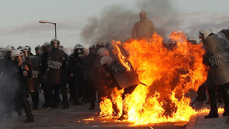Protesters clash with riot police during a mass rally against the new memorandum outside the Greek Parliament in Athens, Greece, 12 February 2012.