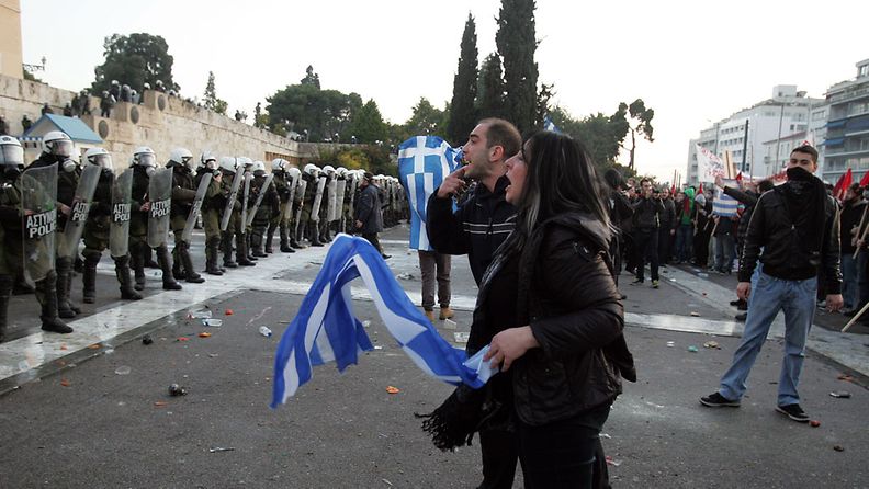 Protesters clash with riot police during a mass rally against the new memorandum outside the Greek Parliament in Athens, Greece, 12 February 2012