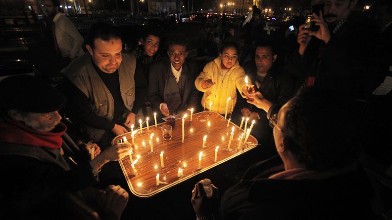 Sadat egyptiläiset kokoontuivat uutenavuotena Kairon Tahrir-aukiolle kynttilävigiliaan.