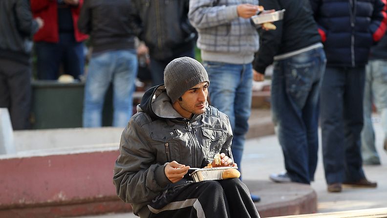 Mies ruokaili soppakeittiön ulkopuolella Ateenassa 15. helmikuuta 2012.