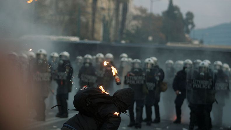 Protesters clash with riot police during a mass rally against the new memorandum outside the Greek Parliament in Athens, Greece, 12 February 2012.