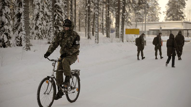 Sotilaspoliisi pyöräilee pakkasessa Pohjois-Karjalan prikaatin varuskunnassa Kontiolahdella 10. helmikuuta 2012. Pohjois-Karjalan prikaatia esitetään lakkautettavaksi vuoden 2013 lopussa.