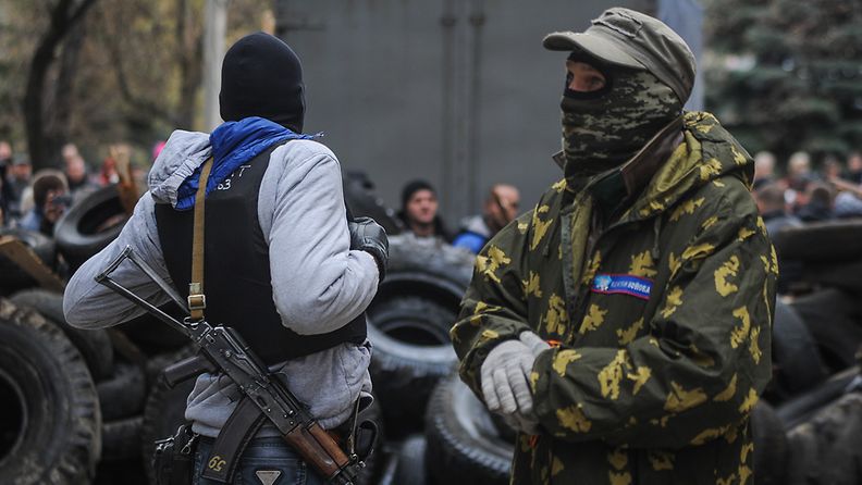 Aseistettuja miehiä vallatun poliisiaseman edessä Slovjanskissa Ukrainassa 12. huhtikuuta 2014.