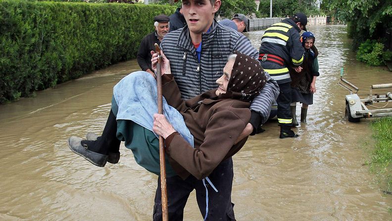 Serbialainen mies kantaa vanhaa naista turvaan tulvien tieltäObrezissa 17.5.2014.