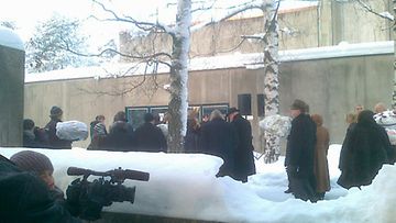 Valokuvaaja ikuistaa Kari Tapion hautajaisiin saapuneita ihmisiä. 