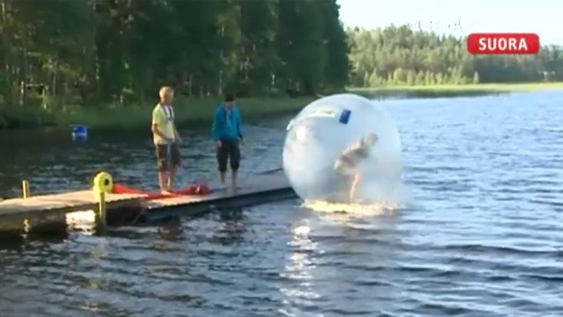 Pääkaupunkiseudun partiolaisten leirillä yhdellä rastilla pääsi palloilemaan veden päälle. Kuvakaappaus Huomenta Suomen lähetyksestä.