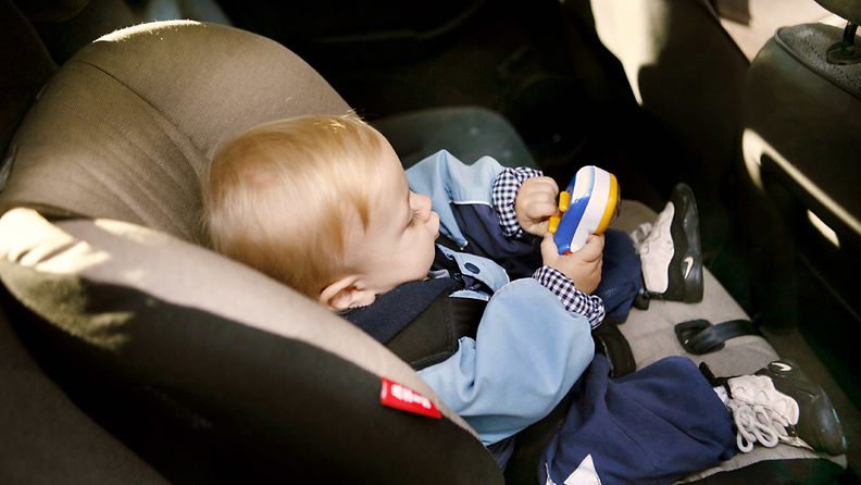 Pieni poika matkustaa auton turvaistuimessa.