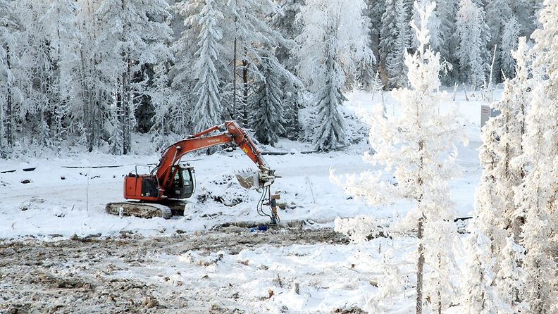 Kaivuri poistaa saastunutta maa-ainesta Ylä-Lumijärveen johtavan Mourunpuron varrella Sotkamossa keskiviikkona 16. tammikuuta 2013. 