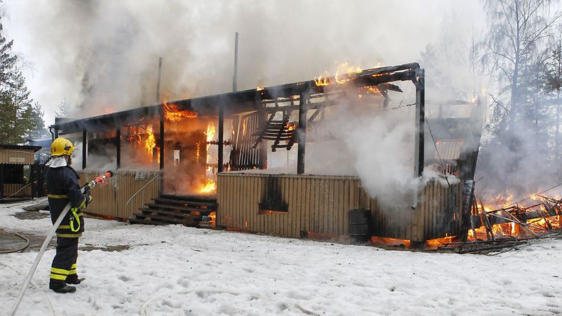 Palomies sammuttaa maineikasta Kyröskosken suurlavaa, joka paloi Hämeenkyrössä tiistaina 17. huhtikuuta 2012.