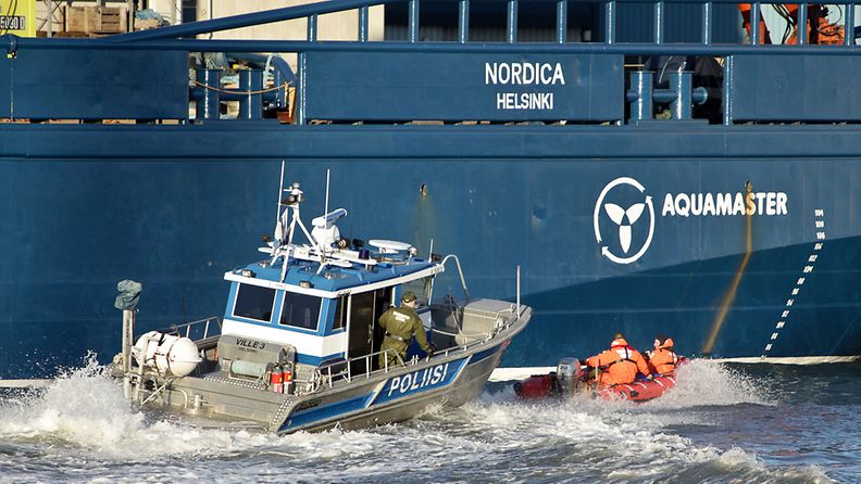Poliisin vene jäänmurtaja Nordican kyljessä Helsingin Hietalahdessa vappupäivänä. Greenpeacen aktivistit yrittivät estää jäänmurtajan lähdön arktisille alueille.