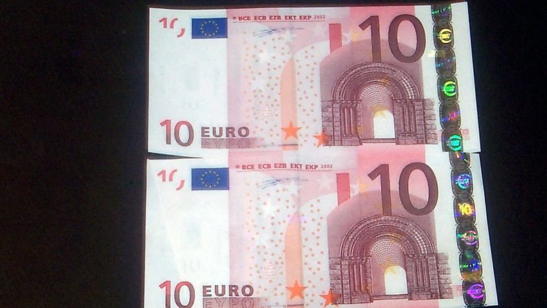 Oikea ja mahdollisesti väärä kymmenen euron seteli. Alemman setelin hologrammi on reilut kaksi millimetriä lähemänä reunaa kuin ylemmän setelin. 