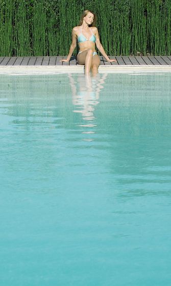 Nainen istuu uima-altaalla