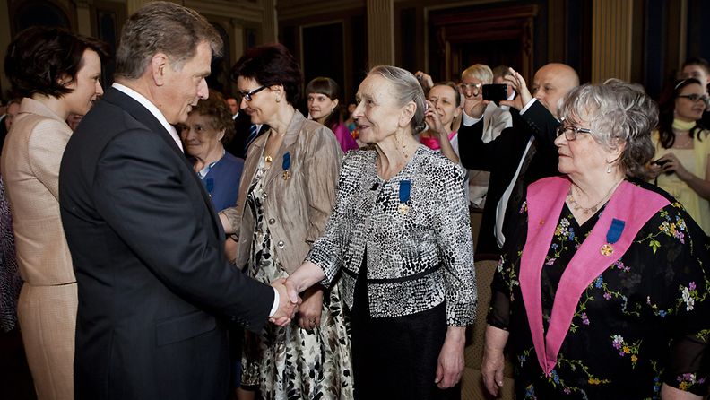 Tasavallan presidentti Sauli Niinistö kättelee Elvi Peltosta valtakunnallisessa äitienpäiväjuhlassa Helsingin Säätytalolla 13. toukokuuta 2012, Niinistön takana rouva Jenni Haukio. 