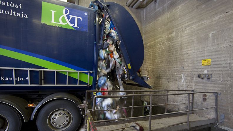 Kuvassa Lassila&Tikanojan jäteauto tyhjennysrampilla, josta jätteet putoavat jätesiiloon.
