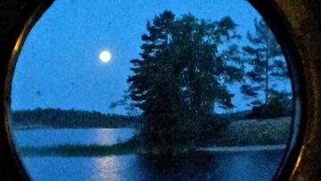 Kaija Kuisma kuvasi aatto yönä kuun höyrylaivan ikkunan läpi Laukansaaressa Saimaalla.