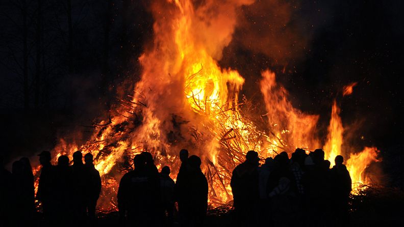 Pohjalaiseen pääsiäisenviettoon kuuluvia kokkoja poltettiin lauantai-iltana Pohjanmaalla, kuvassa ihmisiä pääsiäiskokon äärellä Ilmajoella.