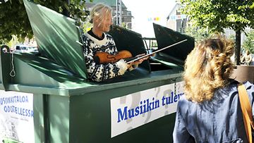 Katusoittaja Teemu Kupiainen soitti Bachia viulullaan roskiksesta Kiasman edessä Helsingissä 26. elokuuta 2010. (LEHTIKUVA)