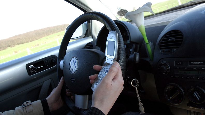 Kuljettaja käyttää kännykkää ajon aikana. 