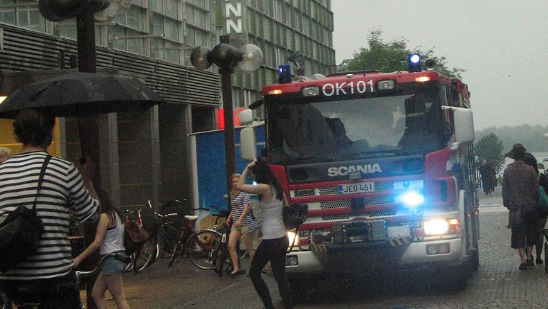 Paloauto kaatosateessa Stockmann-tavaratalon edessä Oulussa 30. heinäkuuta 2012. Ukkoskuuro aiheutti Oulussa useita vesivahinkoja, ja Stockmannin tavaratalo jouduttiin sulkemaan vesivahingon takia. 