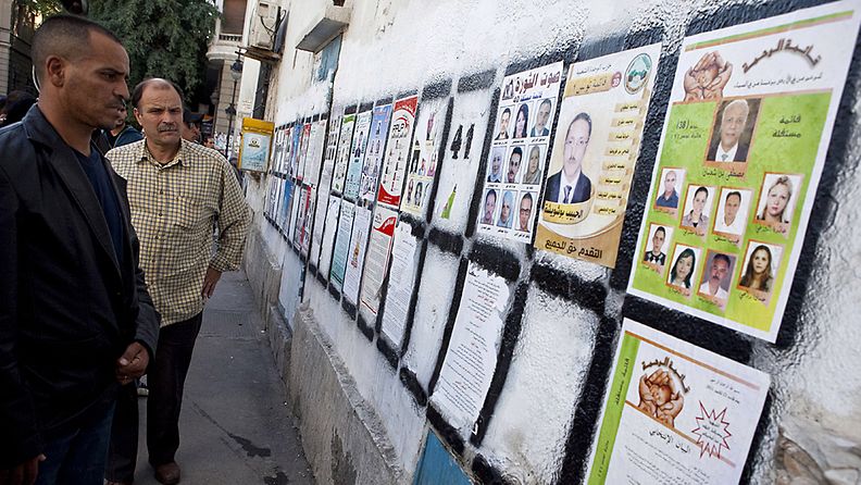 Tunisialaismiehet katsovat ehdokaslistoja Tunisia pääkaupungissa Tunisissa. 