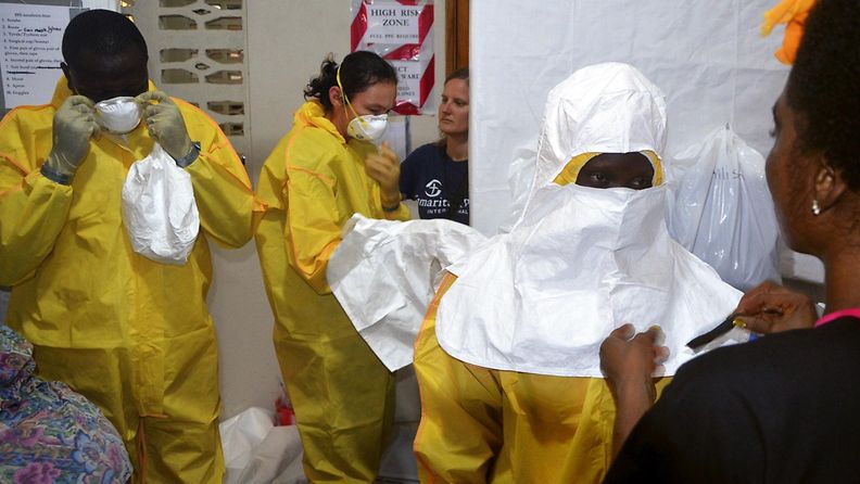 Kristillisen järjestön työntekijät pukevat suojavarusteita sairaalassa Liberian pääkaupungissa Monroviassa 24. heinäkuuta 2014.