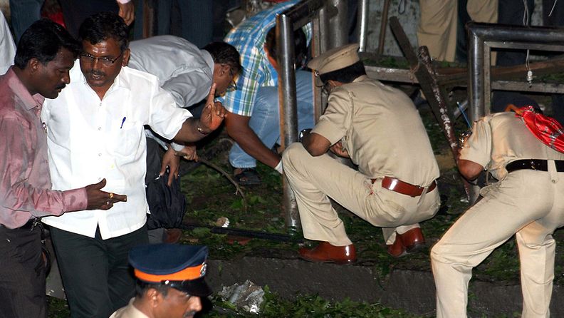 Poliisi tutkii räjähdyspaikkaa Mumbaissa 13.7.2011.