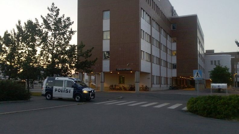 Poliisiauto Oulun oikeustalon edustalla myöhään sunnuntaina 28. heinäkuuta 2013. Poliisitalo on rakennuksen toisessa päässä, ja rakennuksen takana on parkkipaikka, jossa poliisi piiritti aseitautunutta miestä sunnuntai-iltana. 