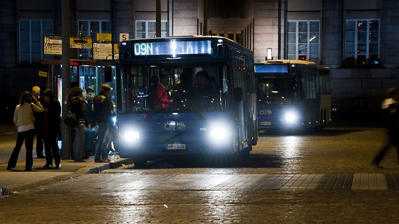 Ihmisiä nousemassa bussiin Rautatientorilla Helsingissä aamuyöllä