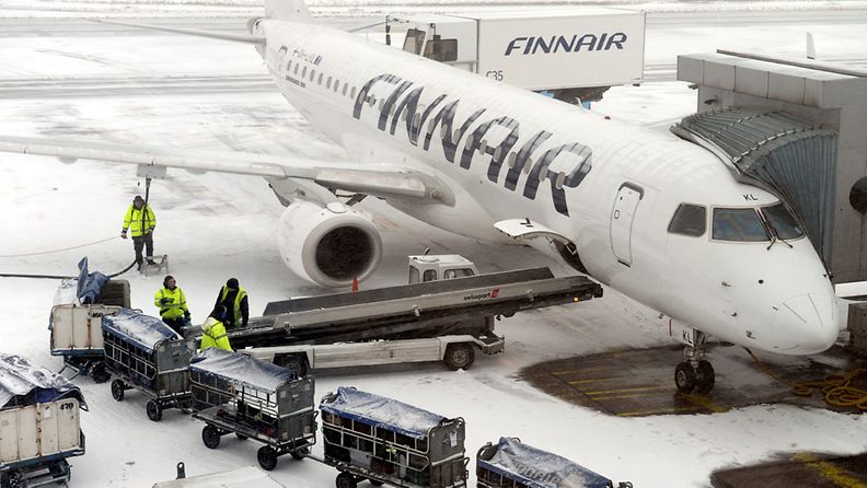 Lentokenttähenkilöitä lastaamassa matkatavaroita Finnairin lentokoneeseen Helsinki-Vantaan lentokentällä keskiviikkona 22. helmikuuta 2012.
