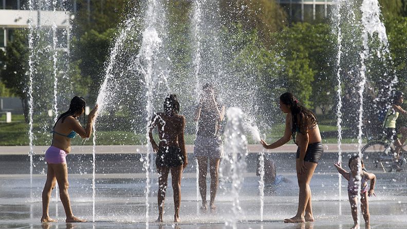Sveitsissä mitattiin 34 asteen lämpötiloja 19. elokuuta 2012. Ihmiset vilvoittelivat suihkulähteessä Genevessä.