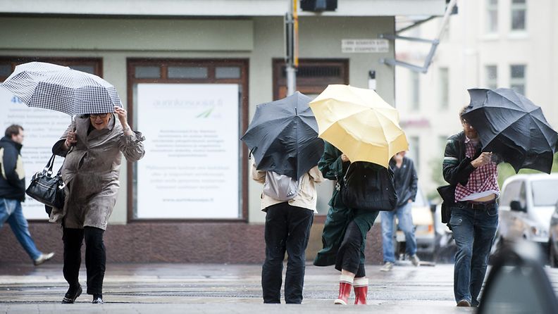 Ihmiset pitivät kiinni sateenvarjoistaan tuulisella Urho Kekkosen kadulla Kampissa Helsingissä 14. syyskuuta 2011.