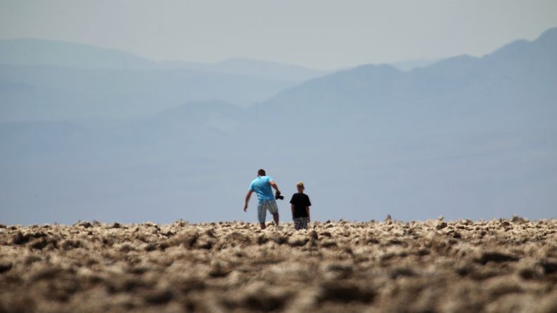 Ihmisiä kävelemässä Kuolemanlaakson kansallispuiston kuumuudessa alueella, joka tunnetaan nimellä Paholaisen golfkenttä 30. kesäkuuta 2013.